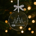 Glass ornament with Christmas tree design and 'DT Companies' logo, hanging on a tree.
