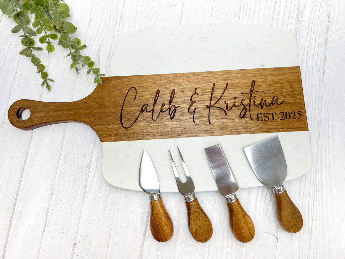 Engraved cutting board that says Caleb and Kristina with four serving tools