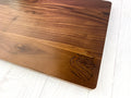 Logo engraved on wooden cutting board in the lower left