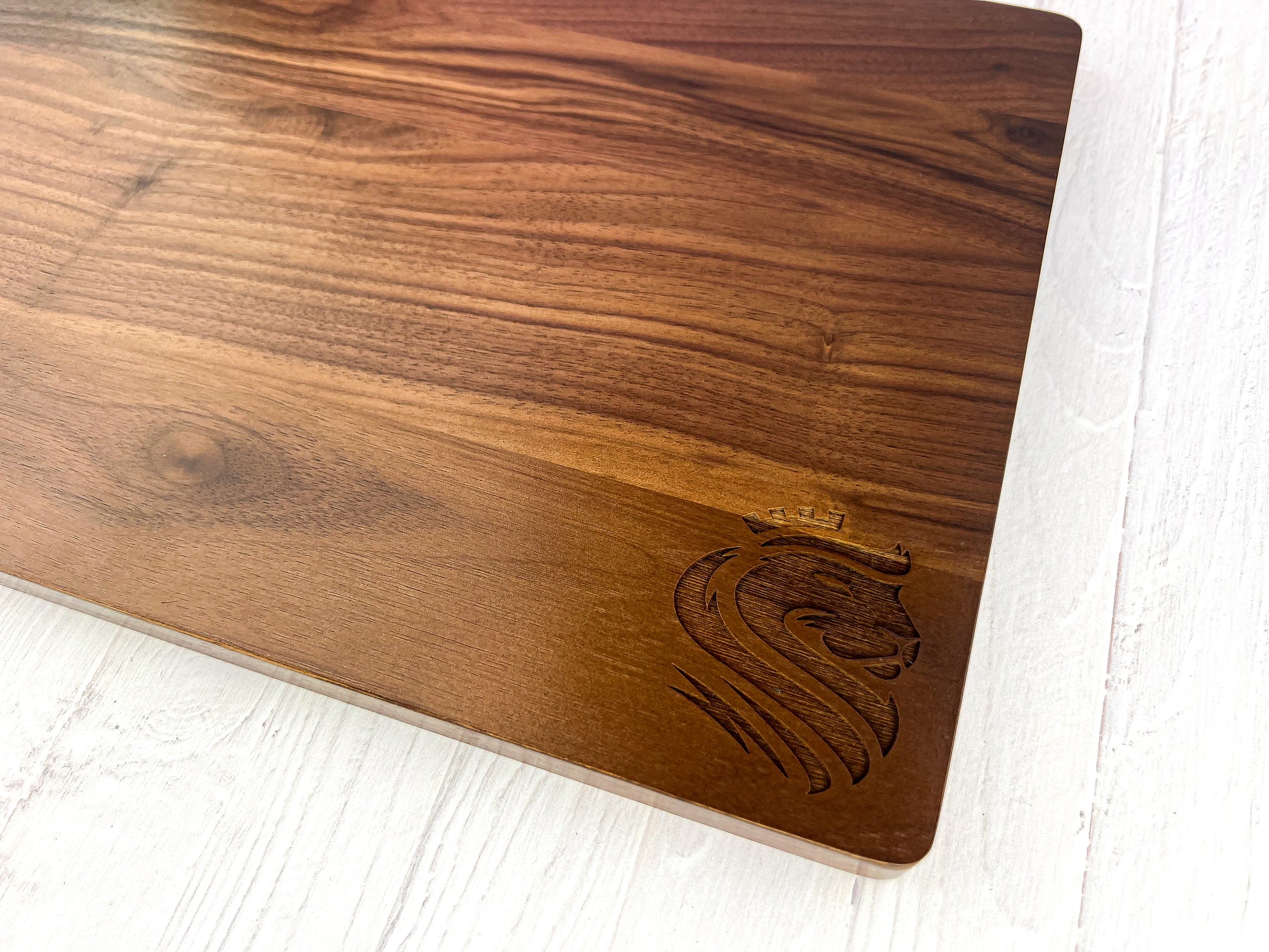 Logo engraved on wooden cutting board in the lower left