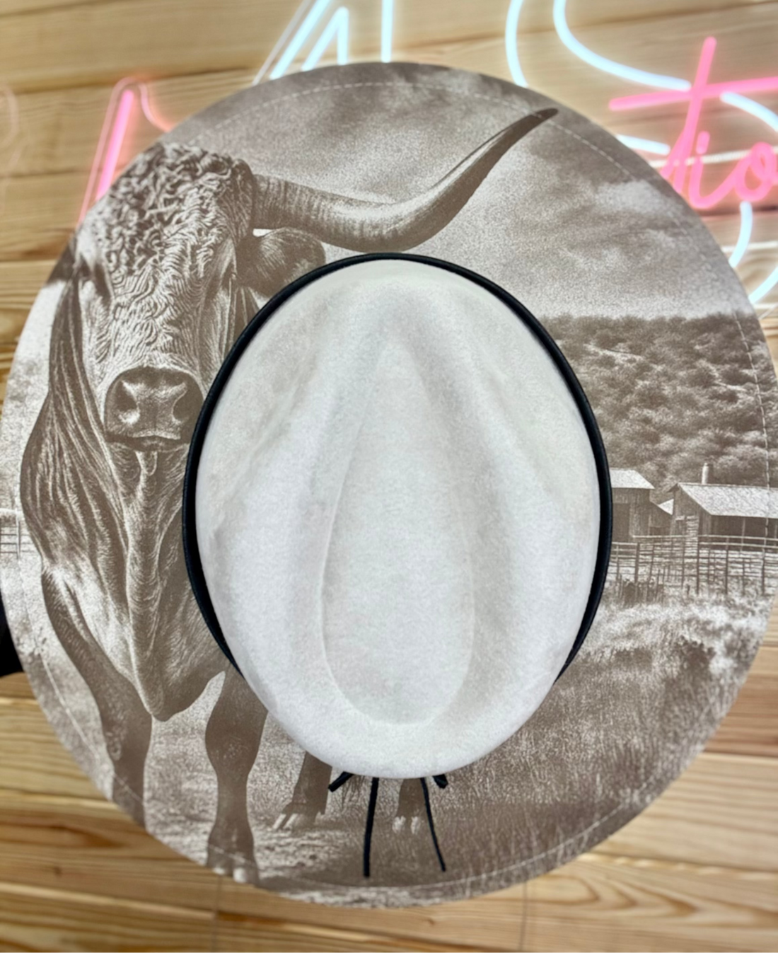 Circular product with cow illustration on a wooden surface with neon lights in the background