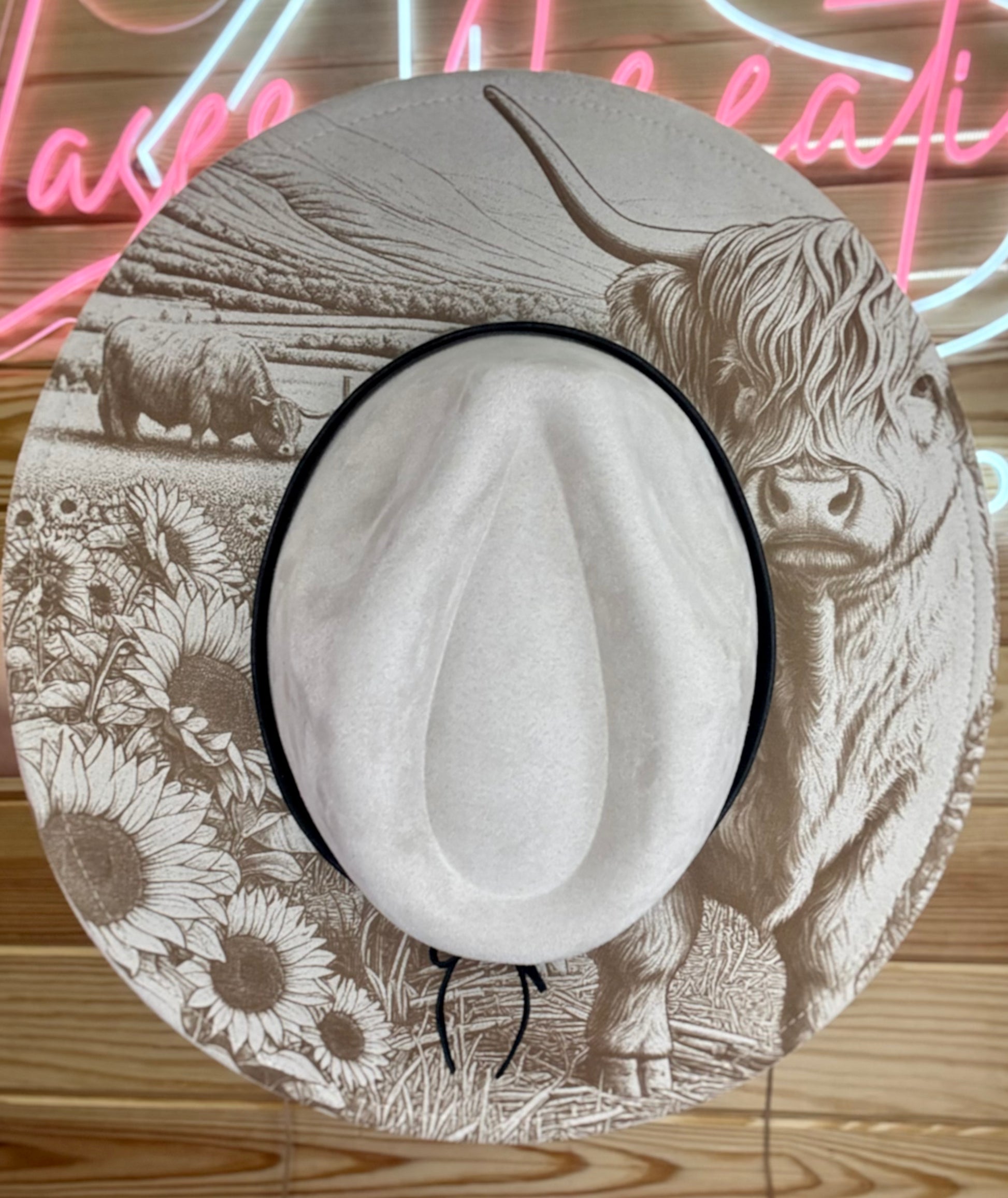 Stone color cowboy hat with band on the crown featuring a highland cow and sunflower design.