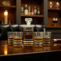 Whiskey decanter and glasses with 'AK Outfitters' branding on a wooden surface.
