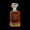 Glass decanter with Foltz branding on a black background