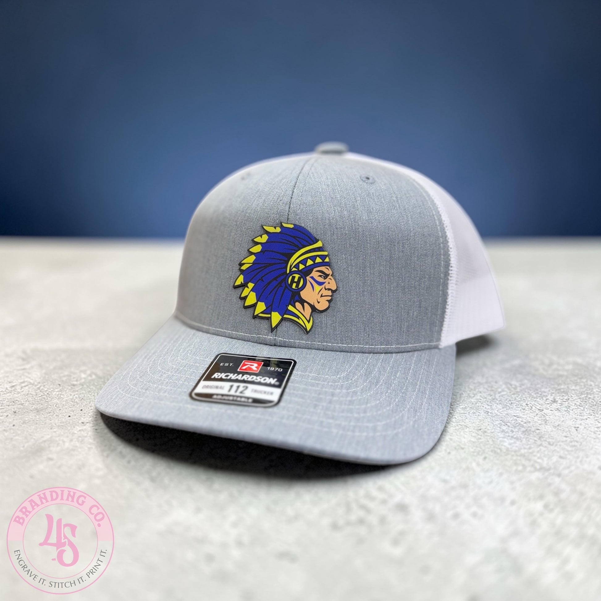 Gray and white cap with a logo on a textured surface and blue background