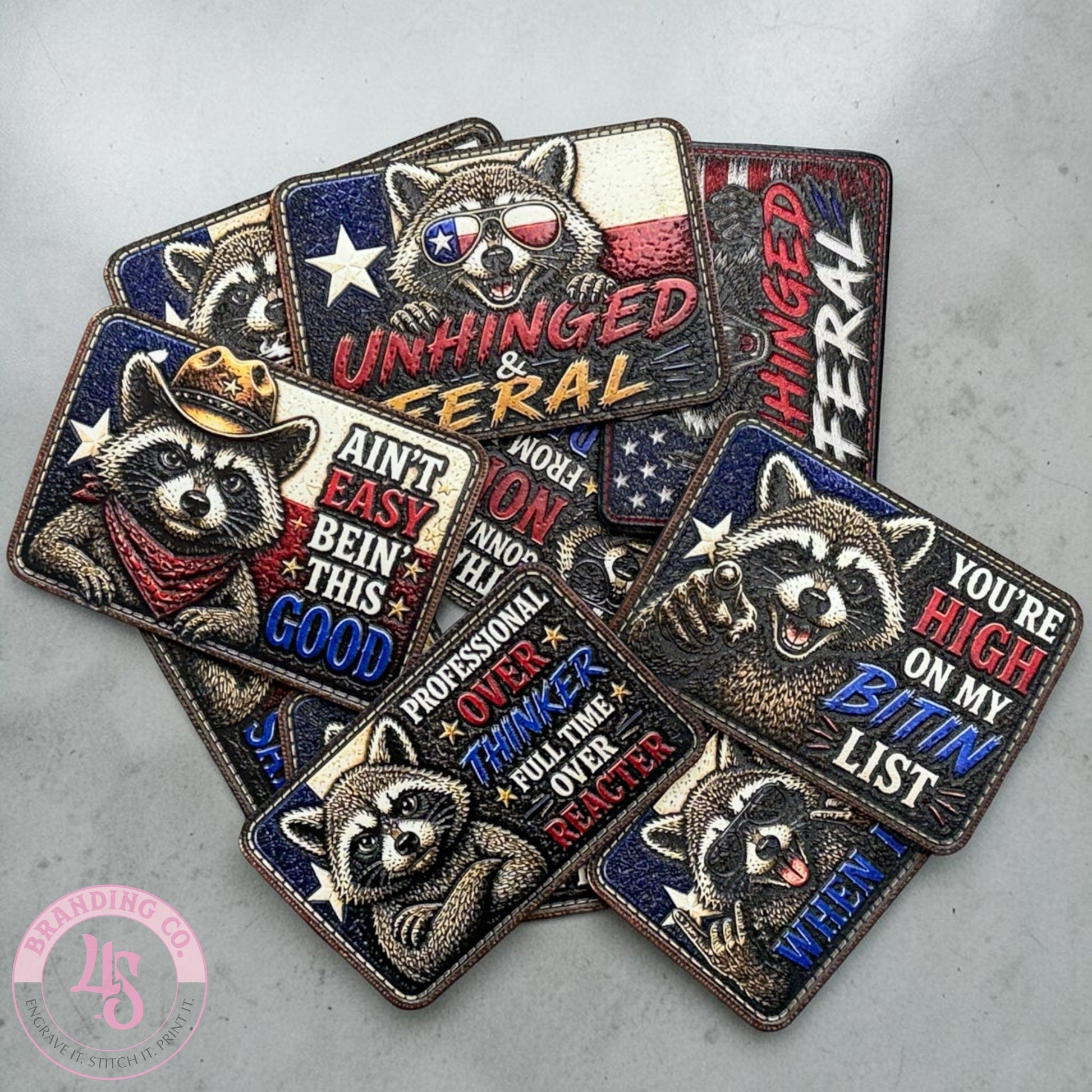 Collection of raccoon-themed patches with text on a gray surface, featuring the brand 'LFG'.
